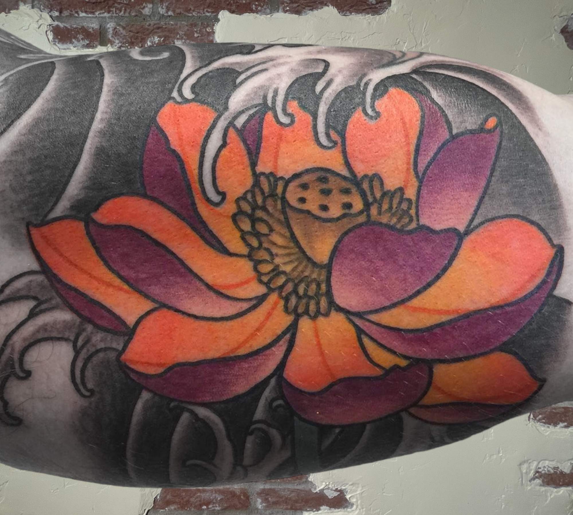 A brightly colored orange and purple floral tattoo by Shannon Byrd of Northwest Arkansas